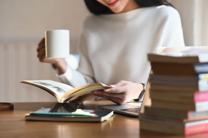 Leader reading and reflecting at a desk with coffee, representing mental fitness, focus, and psychological safety in the workplace