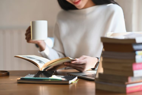 Leader reading and reflecting at a desk with coffee, representing mental fitness, focus, and psychological safety in the workplace