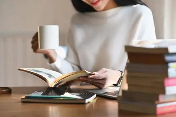 Leader reading and reflecting at a desk with coffee, representing mental fitness, focus, and psychological safety in the workplace
