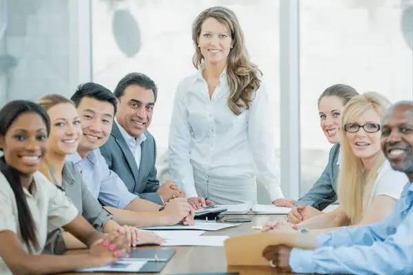 Coaching supports diverse leadership team in a workplace meeting representing real-life leadership pressures, wellbeing and team dynamics